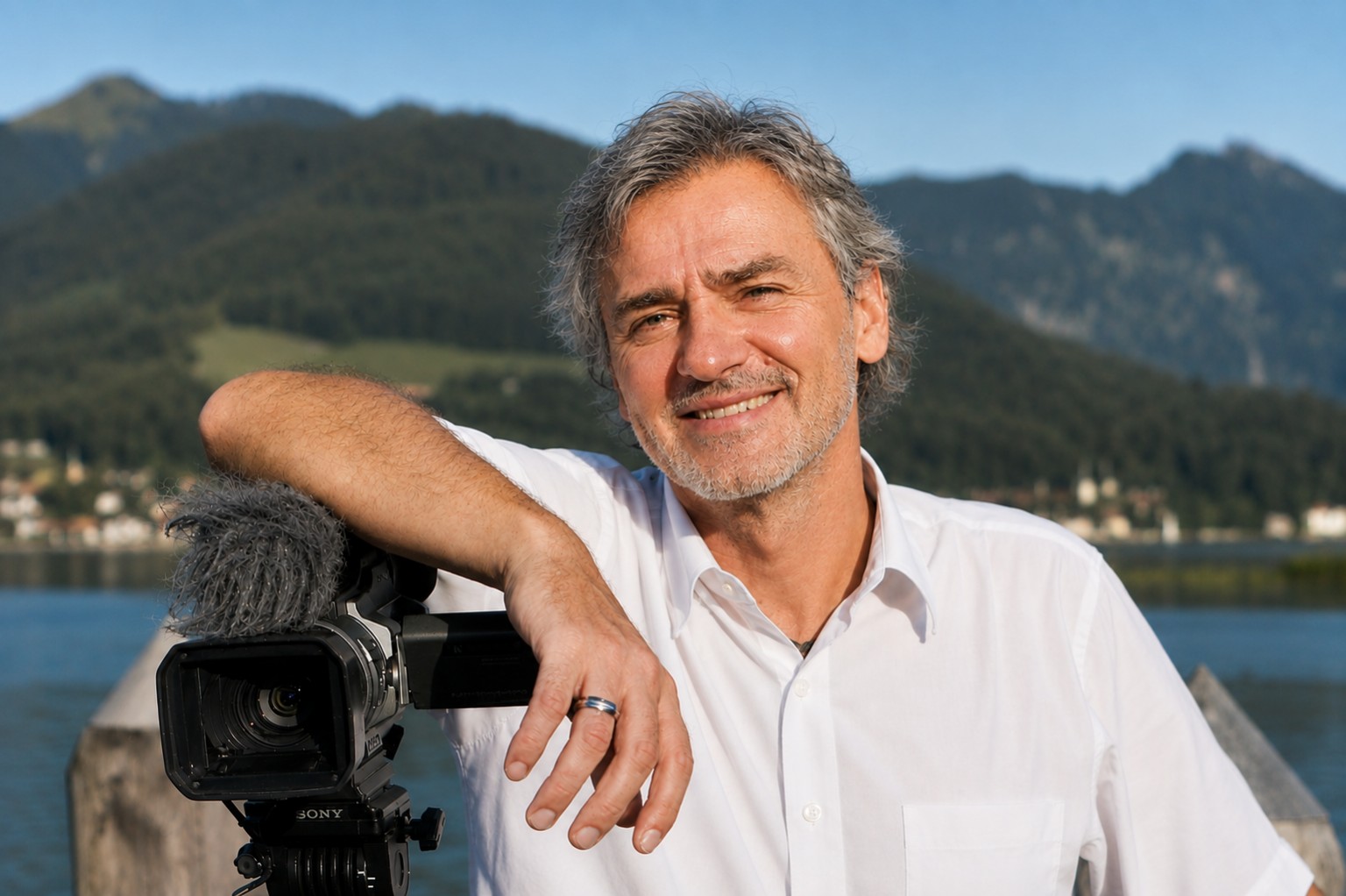 Gregor Kopietz mit professioneller Videokamera vor der Chiemgauer Berglandschaft
